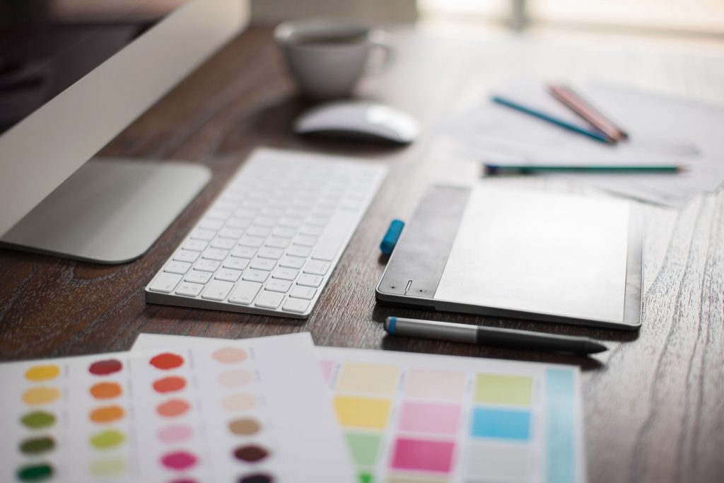 52580872 - shallow depth of field closeup of a graphic designer's workspace with a pen tablet, a computer and some color swatches